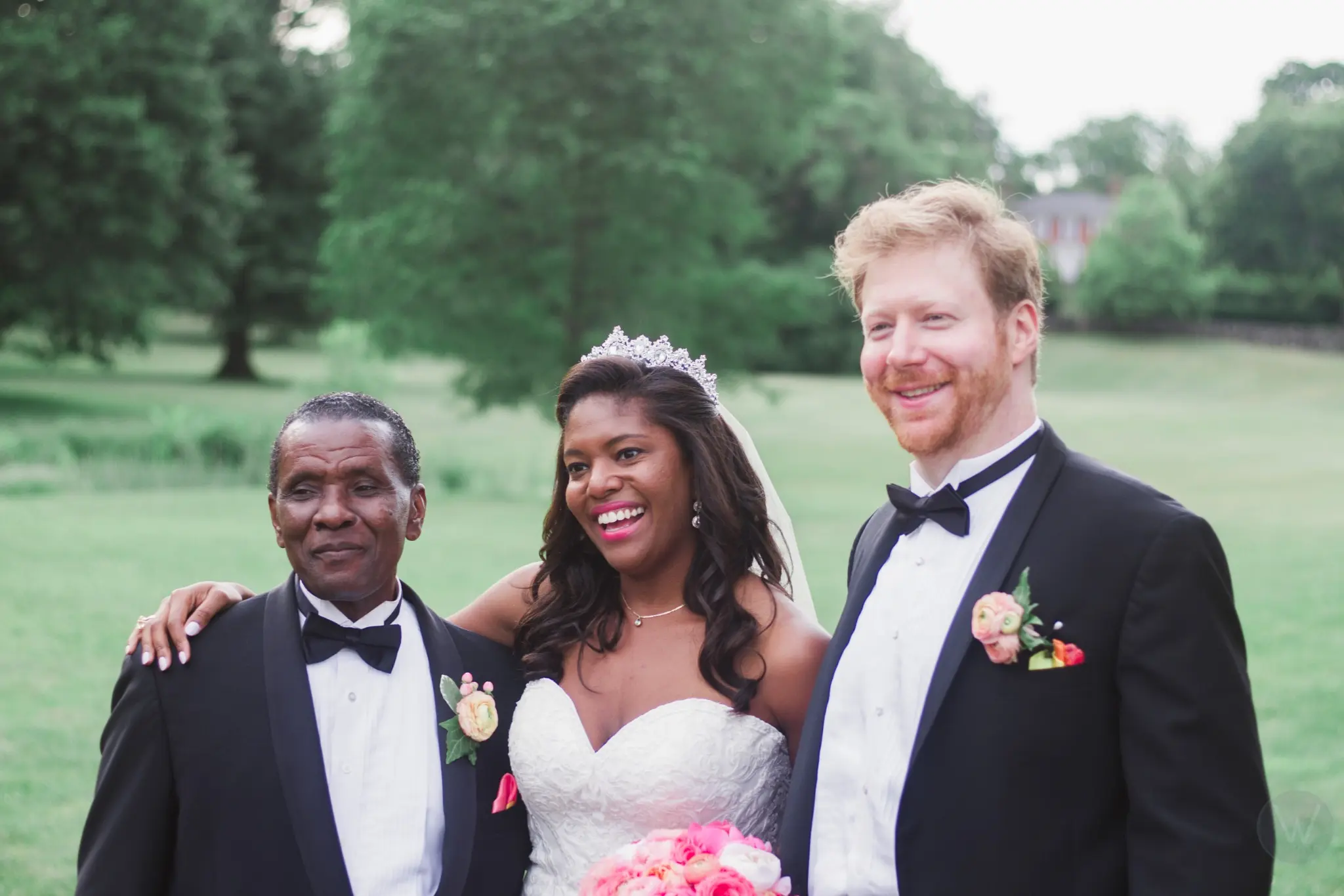 Newlyweds posing outdoors with a wedding guest