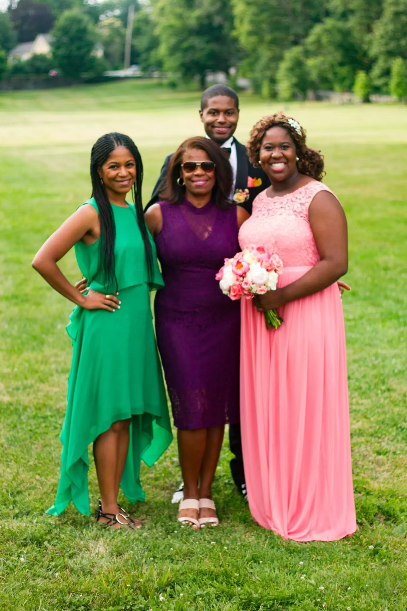 Three women from the wedding party standing together on the lawn