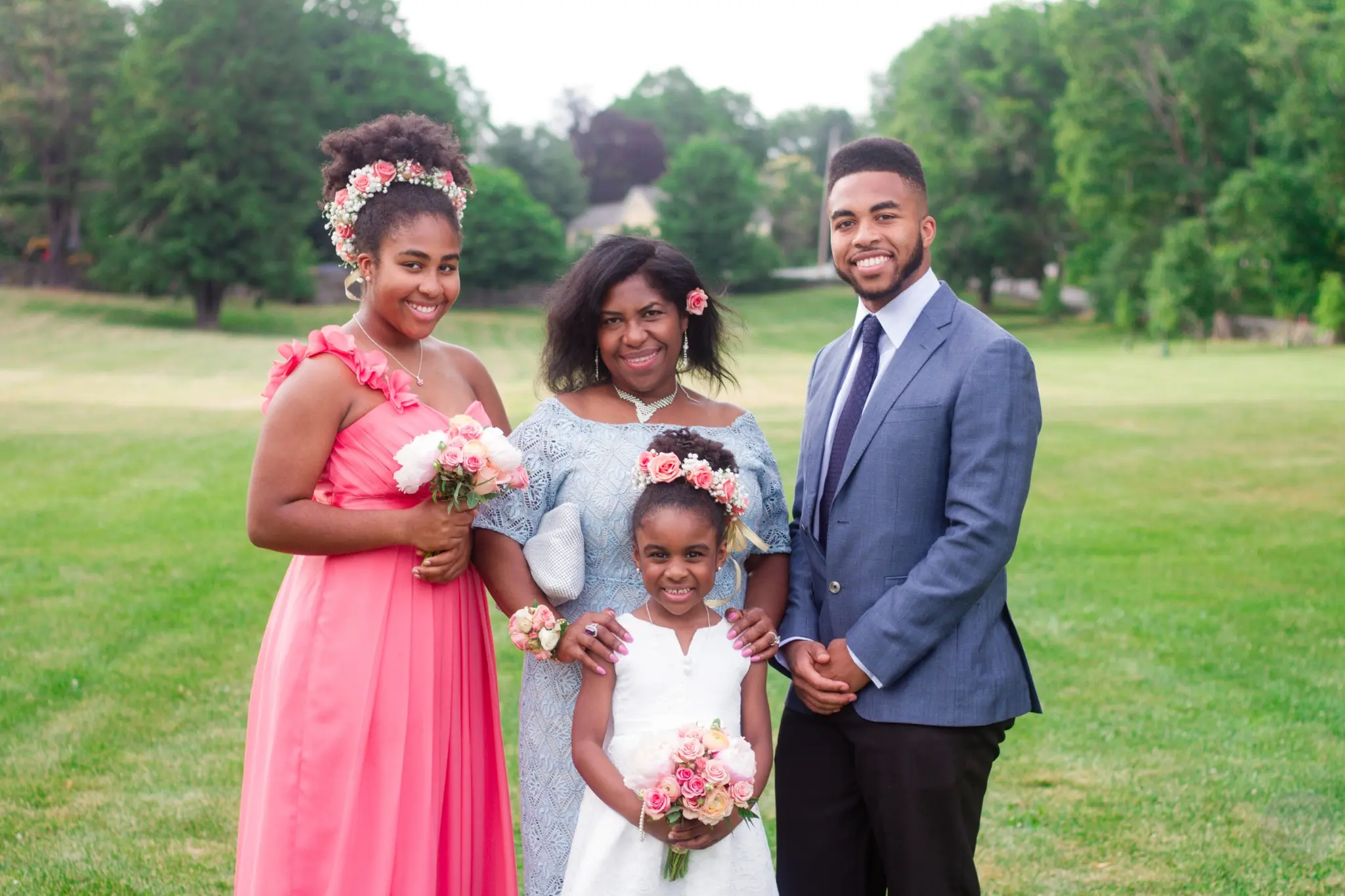 Family group with a flower girl posing at the wedding