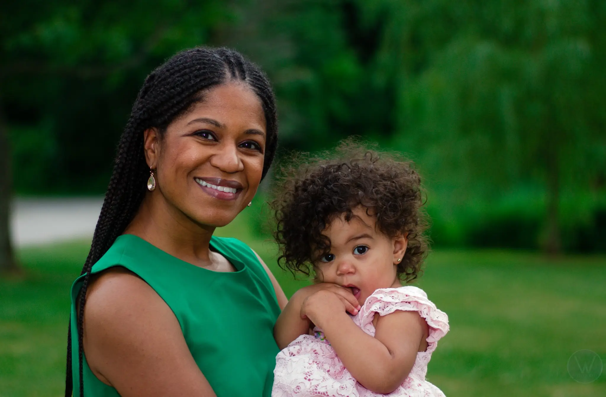 Wedding guest in green holding a young child